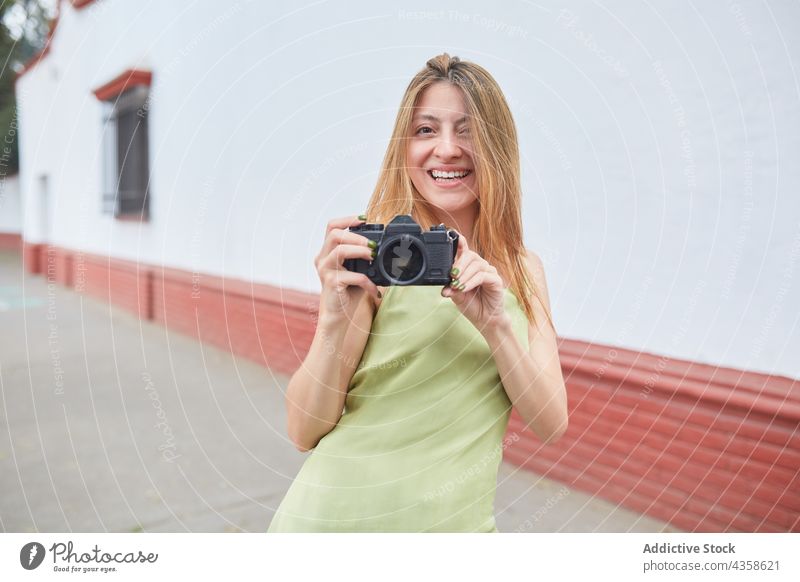 Cheerful woman taking photo on photo camera in city photographer take photo summer urban cheerful photography memory female moment street young weekend device