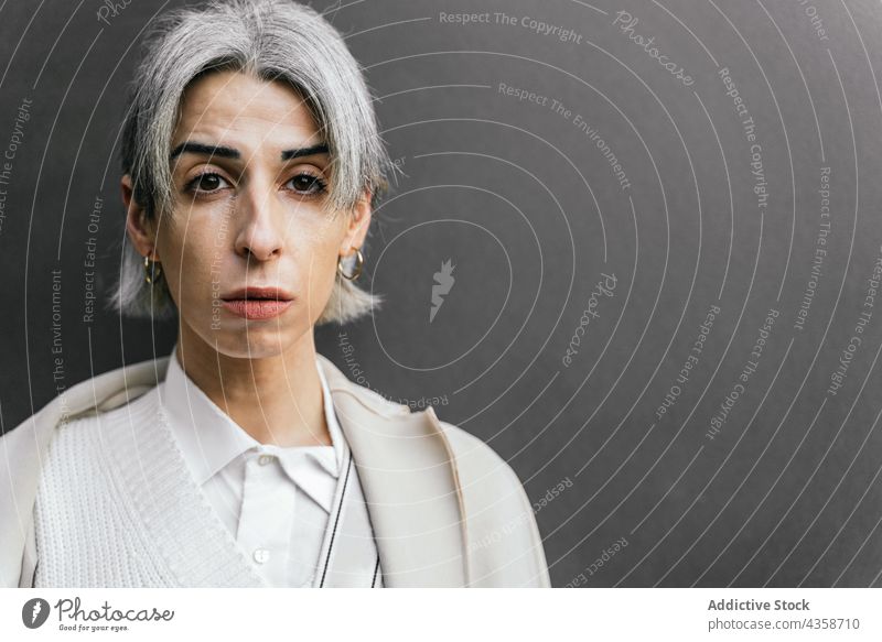 Serious transgender woman with gray hair in street style trendy self assured touch head urban lgbt city female confident determine self confident queer identity