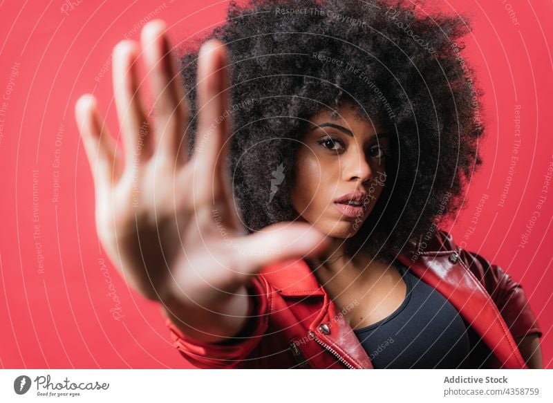 Scared black woman showing stop sign on red background gesture scare protect prohibit no expressive reject female ethnic african american negative aggressive