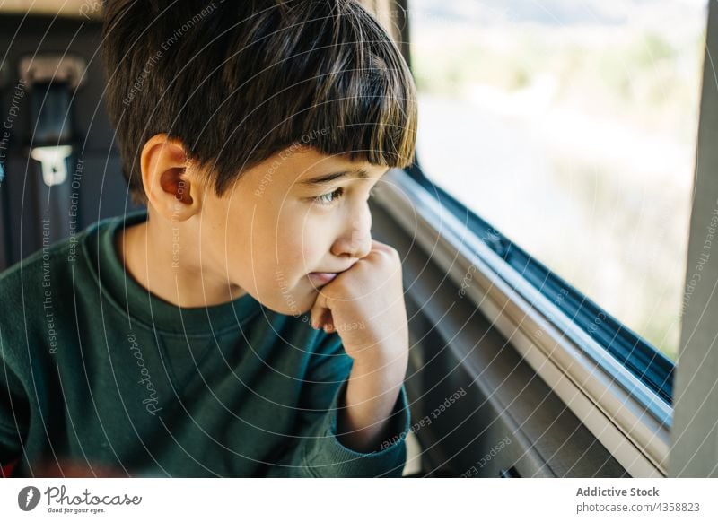 Little boy looking out the window of a motorhome child vacation person childhood motor home horizontal male day transportation road trip travel relaxation