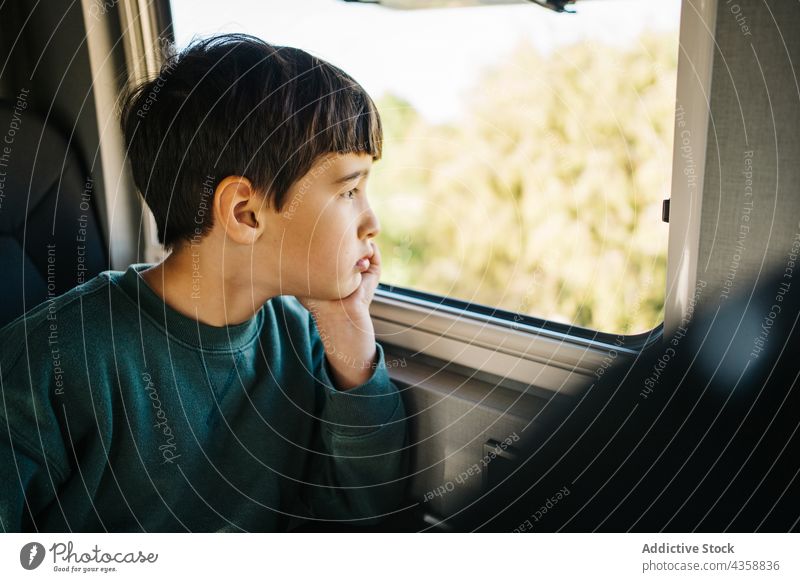 Little boy looking out the window of a motorhome child vacation person childhood motor home horizontal male day transportation road trip travel relaxation