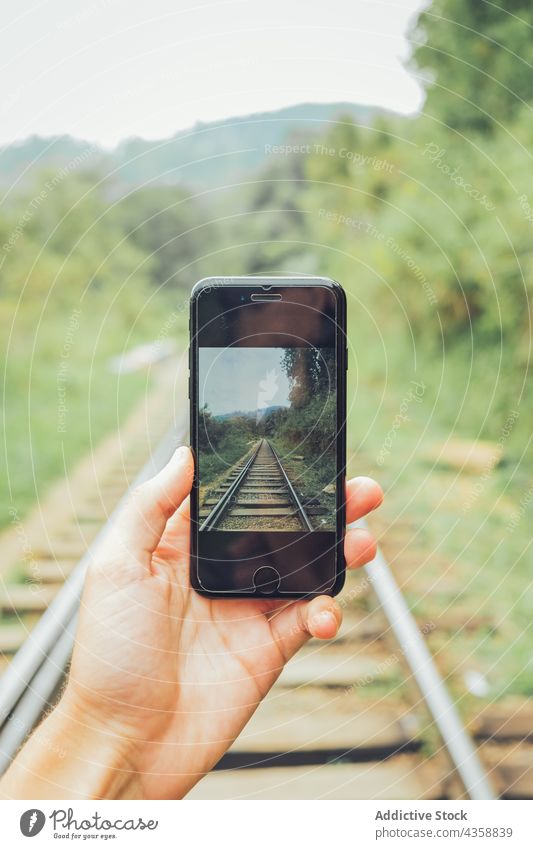 Crop traveler taking photo of railroad on smartphone take photo railway nature mobile gadget device using photography moment memory cellphone tourist journey