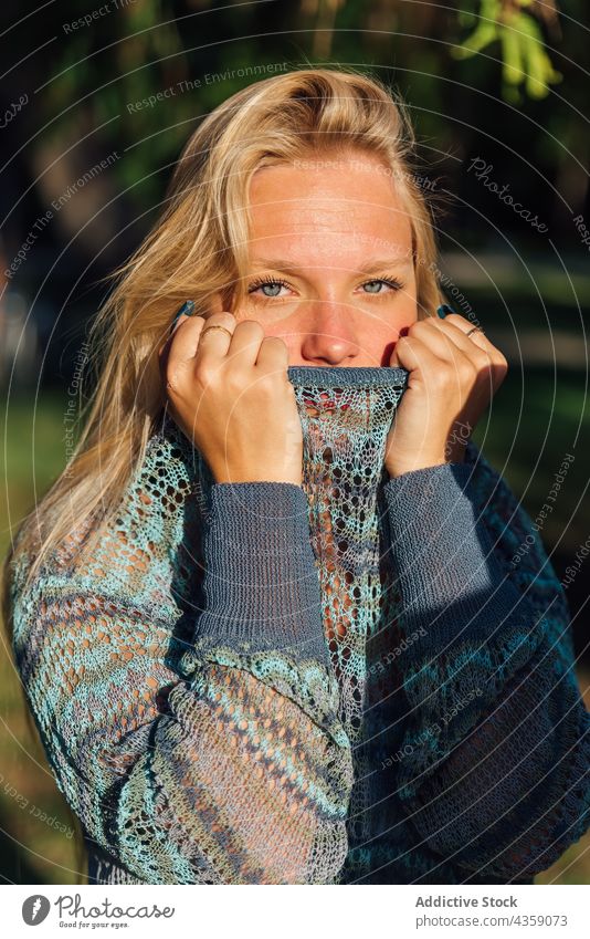 Tender woman in knitted sweater in park at sunset tender cozy gentle blond charming female nature young season tranquil style calm harmony serene evening