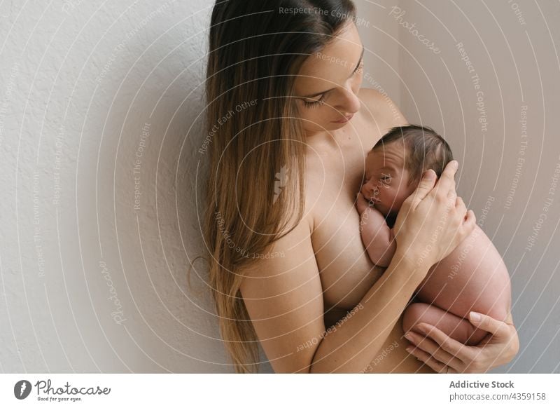 Gentle mother with sleeping newborn at home infant naked together love tender baby care adorable cute topless child wall parent little babyhood eyes closed