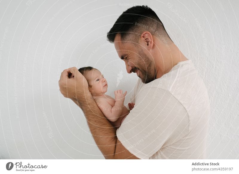 Caring father with newborn at home infant baby care love tender parent sleep innocent cute adorable fatherhood peaceful dad man room together little bonding