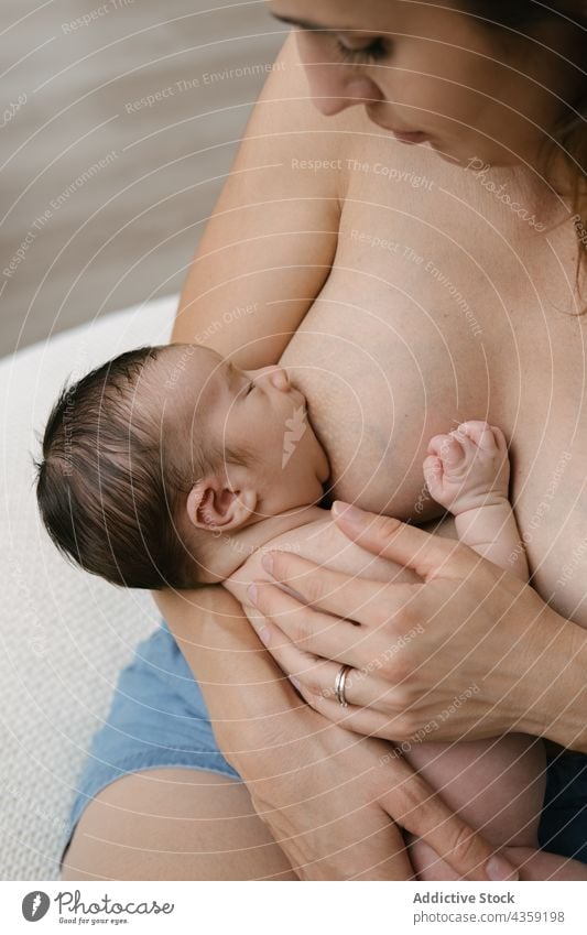 Anonymous mother breastfeeding baby in room at home newborn love together tender milk woman female care parent motherhood suck nourish idyllic nutrition mom