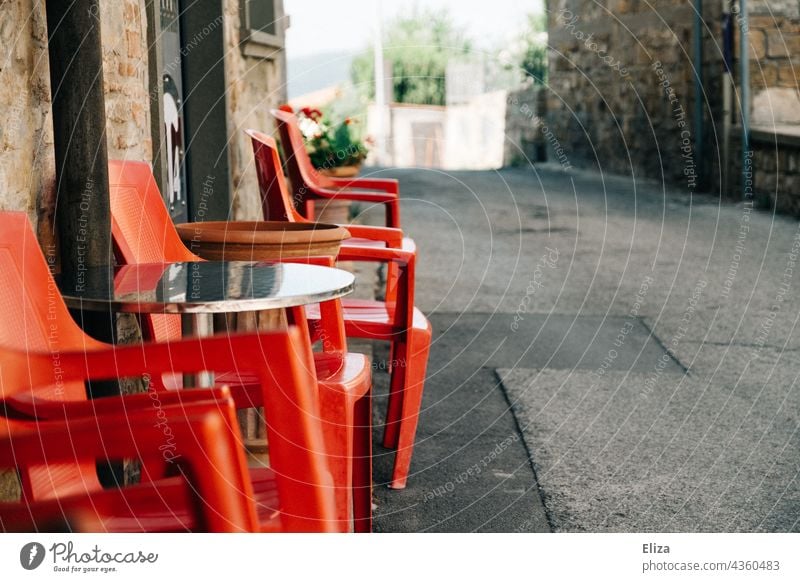 Red plastic chairs in front of a café in an Italian old town Café Plastic chairs Gastronomy out Old town Italy Alley Sidewalk café Empty Terrace Summer Seating