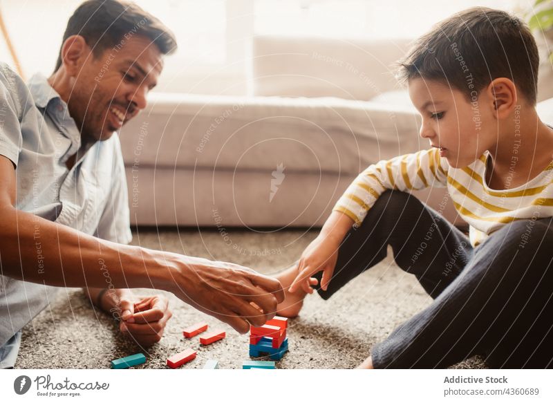 Father and son playing with construction pieces in the dining room child father block brick together toy boy family man childhood education game smile build