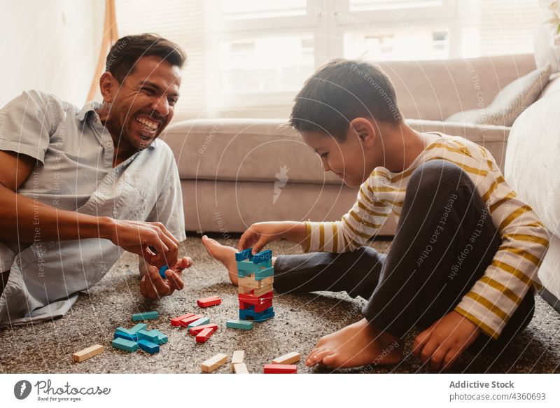 Father and son playing with construction pieces in the dining room child father block brick together toy boy family man childhood education game smile build