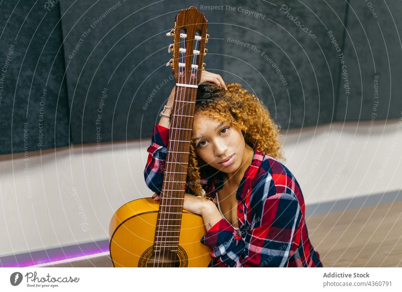 African American musician with guitar resting on floor indoors guitarist art classic acoustic millennial woman portrait charming sit african american string