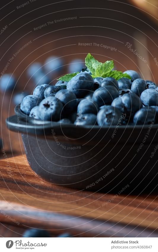 Blueberries in a bowl on the wooden table blueberry food fruit healthy dessert leaf fresh sweet juicy tasty organic ingredient nature raw diet nutrition rustic
