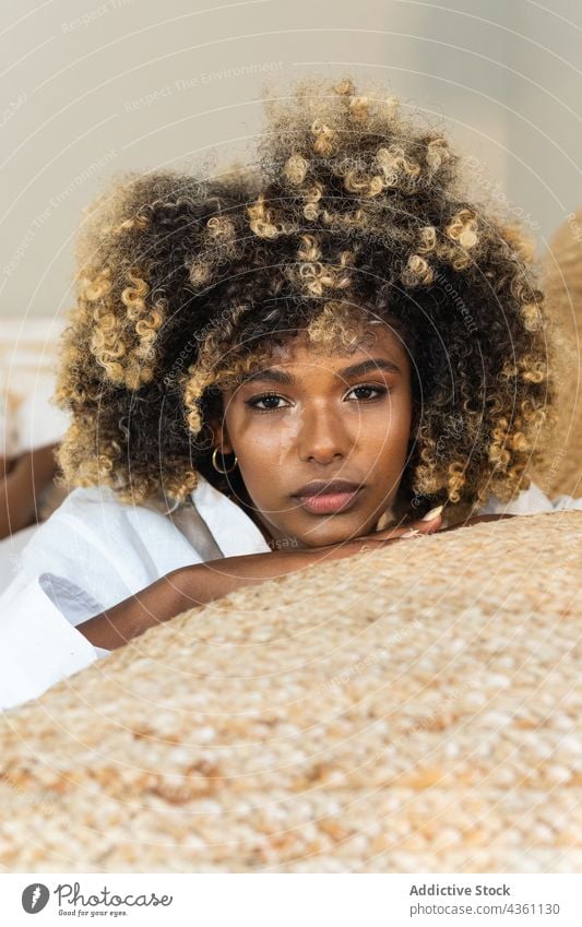 Thoughtful black woman lying on bed in bedroom enjoy rest positive comfort relax morning pleasure female happy optimist delight cheerful toothy smile home glad