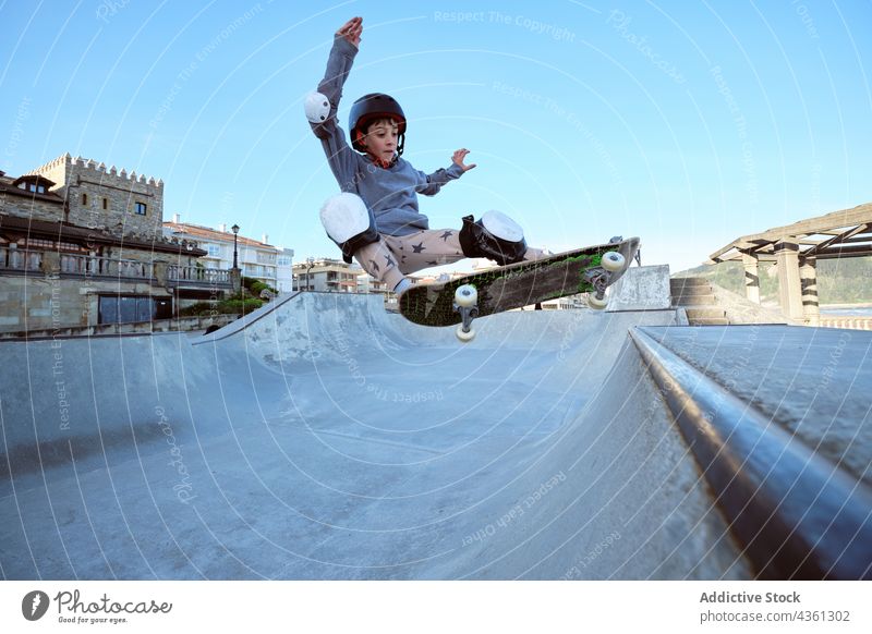Teenage skater riding on ramp in skate park boy skateboard ride trick teenage stunt seaside extreme activity energy hobby active sunny sunlight skill summer