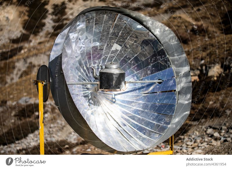 Kettle placed on solar cooker in mountains kettle highland alternative sunny energy panel renewal himalayas nepal metal environment water hot nature boil heat