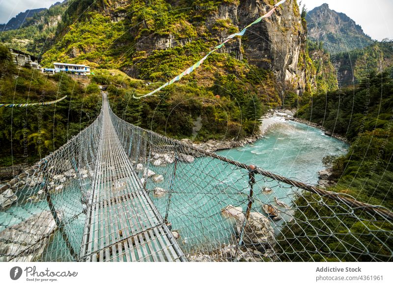 Suspension bridge over river in mountains suspension footbridge highland landscape location metal scenery himalayas nepal construction nature destination summer