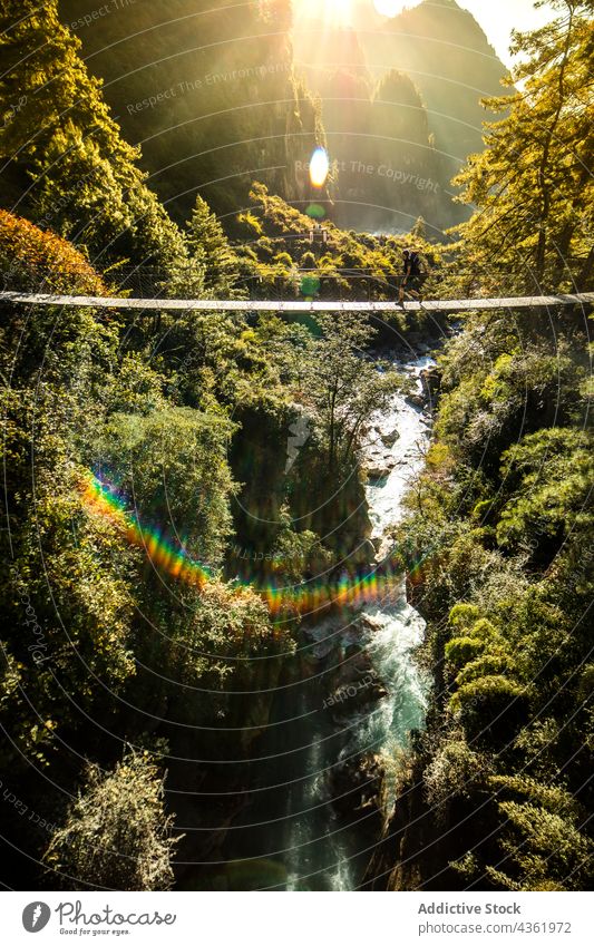 Traveler on suspension bridge over river in mountains traveler footbridge explore highland walk himalayas nepal range nature wanderlust destination location