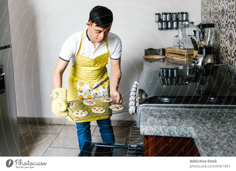 Latin teen boy with Down syndrome preparing cookies in kitchen down syndrome oven prepare disorder mental dessert ethnic latin teenage pastry sweet bake food