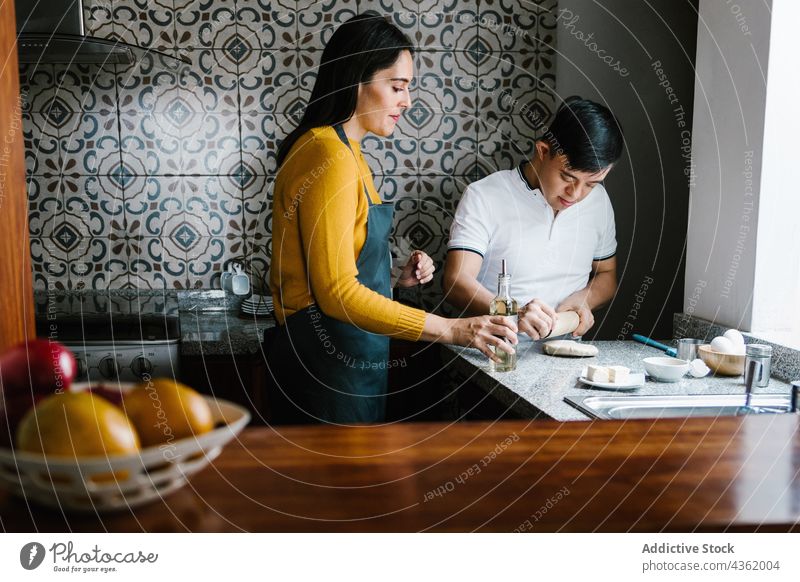 Latin mother and son with Down syndrome cooking together in kitchen down syndrome dough handicap food parent ethnic latin motherhood parenthood homemade