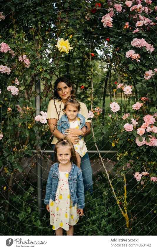 Loving mother with little daughters in blooming park flower happy kid love together summer sibling smile cute child mom garden relationship similar children
