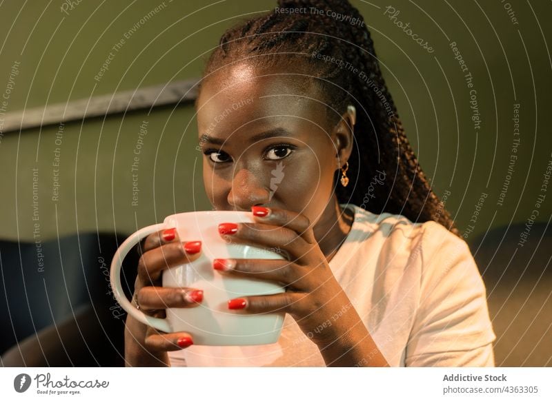 Smiling African American woman with cup of coffee in cafe drink chill cheerful weekend enjoy beverage female ethnic black african american mug braid tasty happy