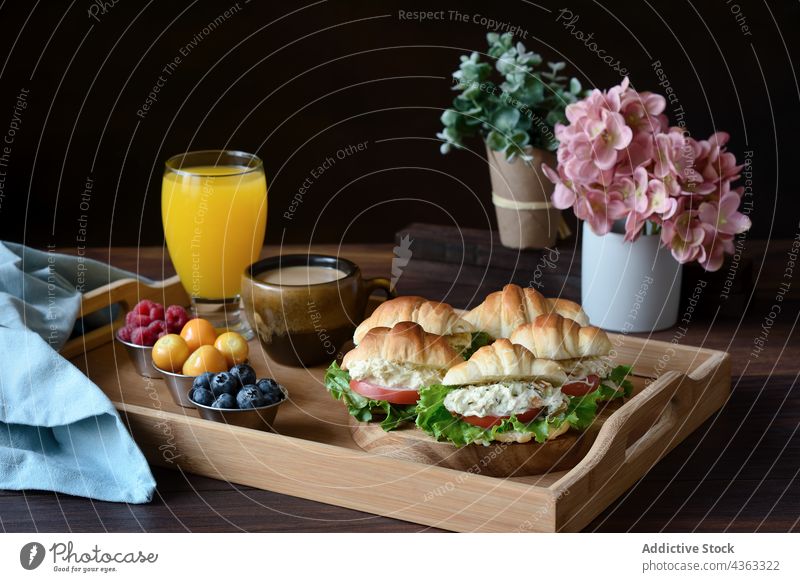 Appetizing French breakfast with croissant sandwiches on tray food juice coffee tasty serve table delicious fresh berry glass cappuccino yummy drink vegetable