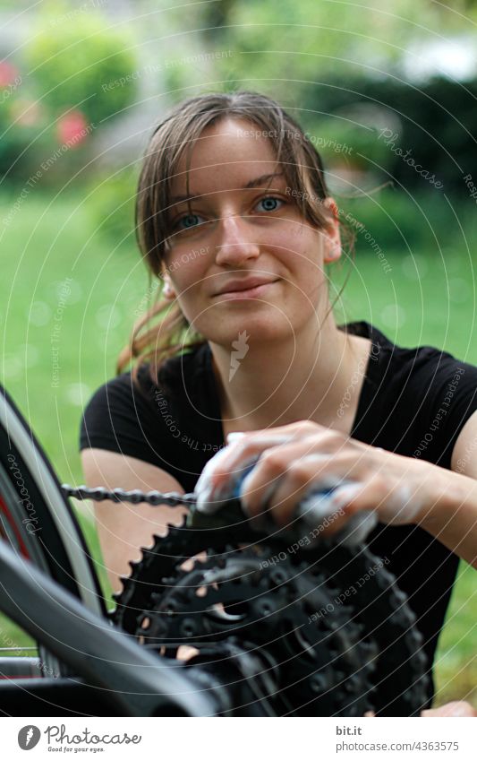 Young woman cleaning the chain of her bicycle, outside in the garden. teenager Adults Woman pretty Floor cloth polish Plaster Wheel Bicycle cyclists Cycling