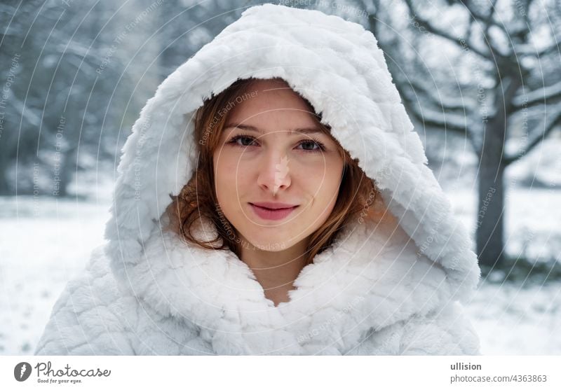 Portrait of a beautiful cute sexy seductive young girl outside in nature in the cold winter with white coat and hood happy warm woman lips desire sensual head