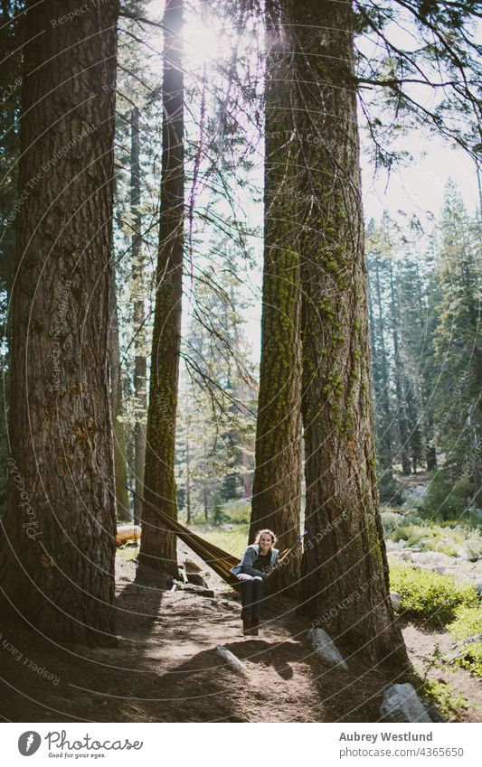woman sitting in a hammock in the woods adults america california culture destination exploration explore exploring forest fresh giant hiker hiking holiday