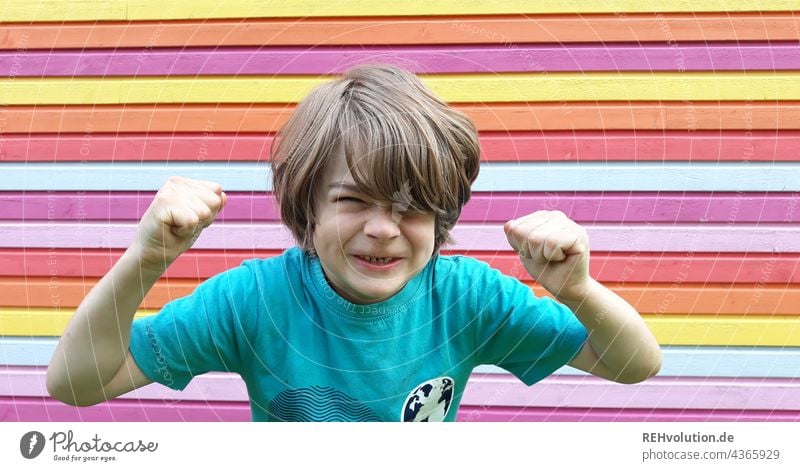 Child is angry in front of a colorful wall Boy (child) Anger outburst of fury Aggravation variegated Emotions Aggression Grouchy Frustration Animosity Moody