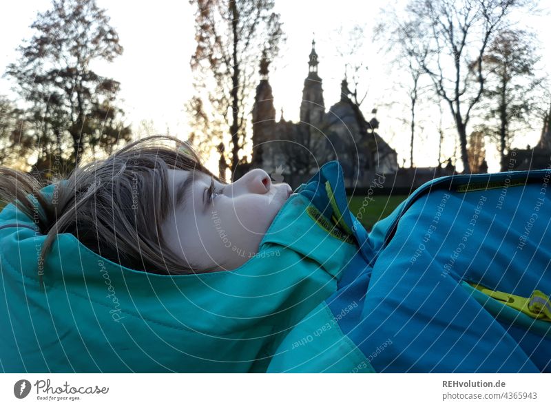 Child lying in front of the Fulda Cathedral portrait Upper body Day Exterior shot Infancy Boy (child) Face Lie Close-up Sunlight Dome Profile Jacket Cold Belief