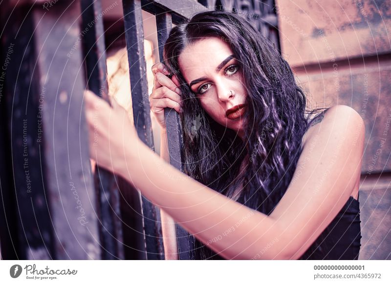 Sad girl portrait clinging to a gate urban sad woman young female beautiful fashion people person city street beauty lifestyle caucasian adult outdoor white