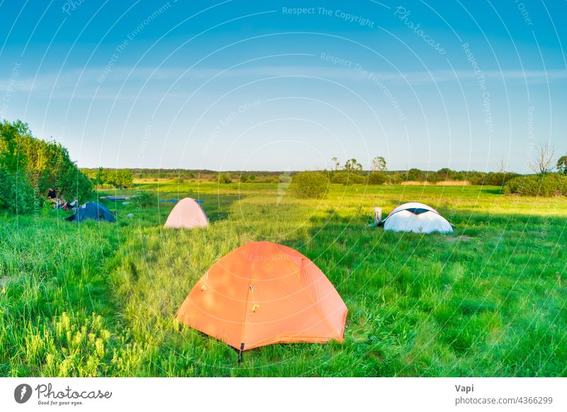 Tent camping on green grass field sunset tent forest sky nature hiking orange yellow adventure travel landscape tourism sunrise summer scene morning outdoor