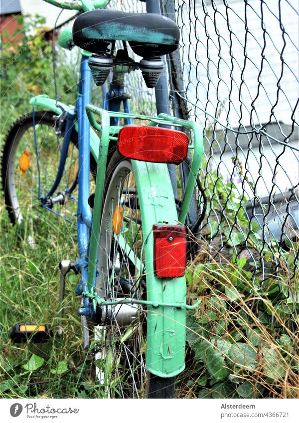 Painted blue green bicycle leaning against wire fence standing on wild green top view rear wheel Bicycle Green Blue Fence Old city bike Transport Mobility