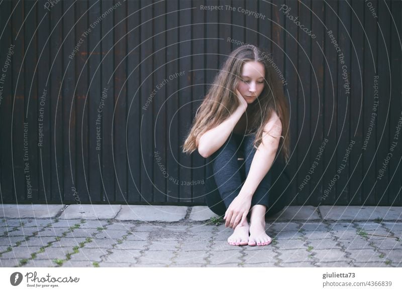 Portrait of a teenage girl, sitting outside on the ground, alone, sad, hopeless portrait Puberty Long-haired Neutral Background Lovesickness Sadness