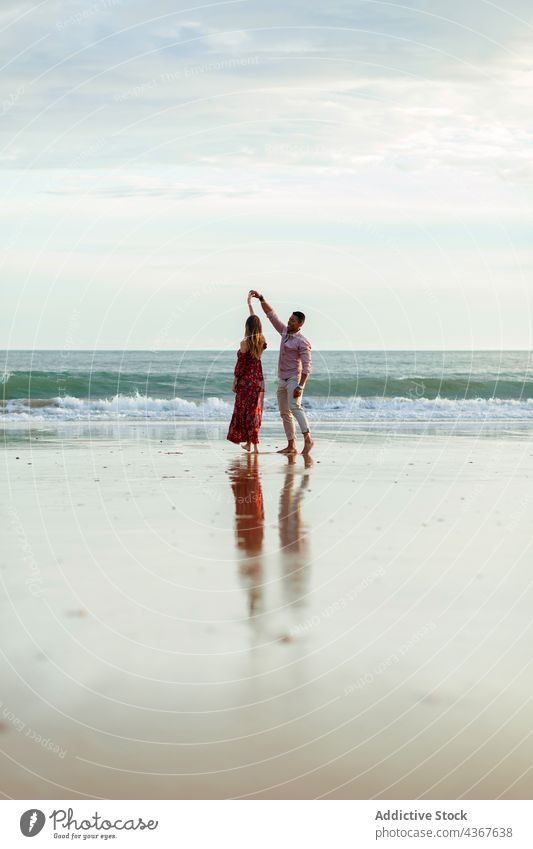 Loving couple dancing on wet seashore in evening romantic beach sunset dance love holding hands together elegant coast romance relationship ocean girlfriend