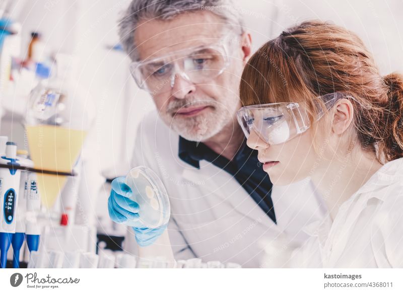Health care professionals in lab. analyzing assistant beaker bio biology cell chemistry clinic coat develop discover dna doctor education equipment experiment
