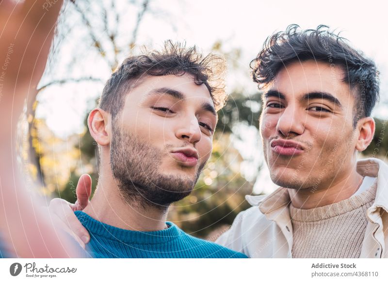 Happy LGBT couple of men taking selfie in park self portrait cheerful homosexual lgbt having fun gay together same sex happy smile weekend male memory moment