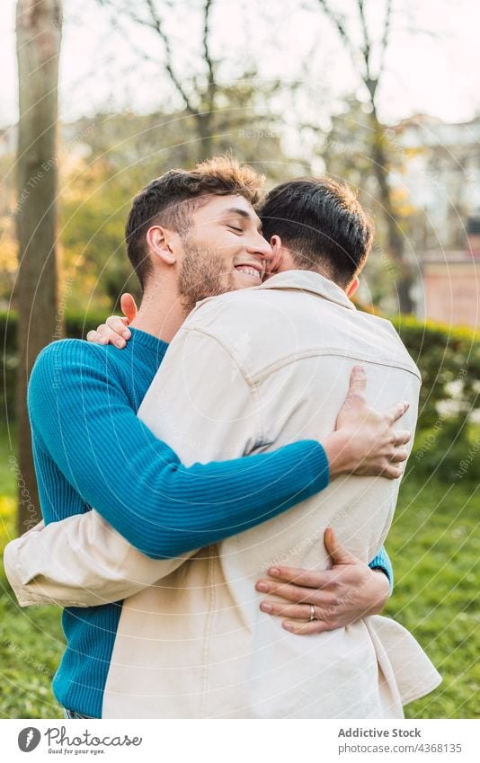 Loving homosexual couple of men hugging in park love embrace gay lgbt boyfriend relationship male together romantic cheerful affection fondness bonding romance