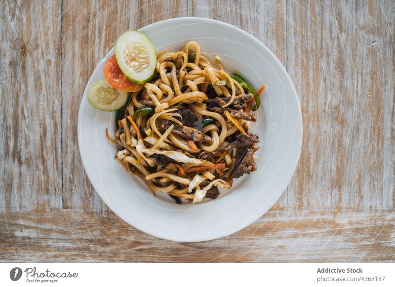 Delicious noodles with beef and fresh vegetable slices asian food lunch dinner meal nutrition delicious plate dish tasty oriental cucumber tomato cut carrot