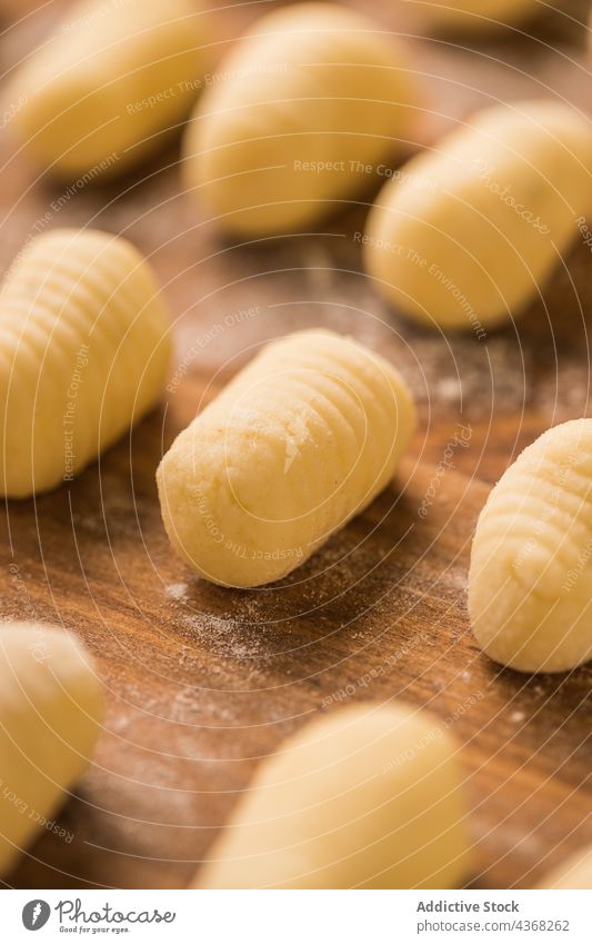 Raw gnocchi on wooden table raw pasta cook row kitchen home lunch food meal prepare dish cuisine portion culinary italian tradition authentic fresh lumber