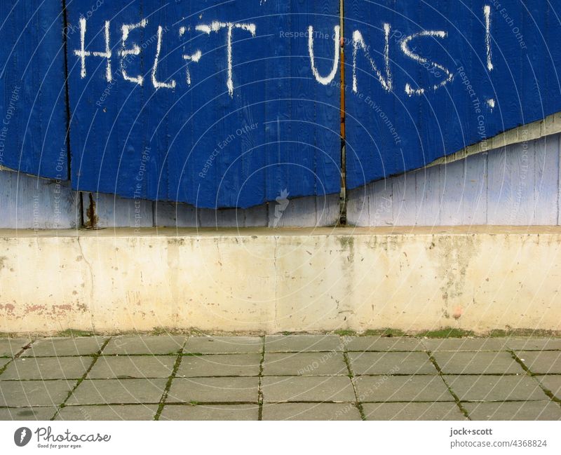 HELP US! Concrete wall Wall (barrier) Sidewalk Paving tiles Structures and shapes Blue Gloomy Curved Spray Word German Street art Capital letter Creativity