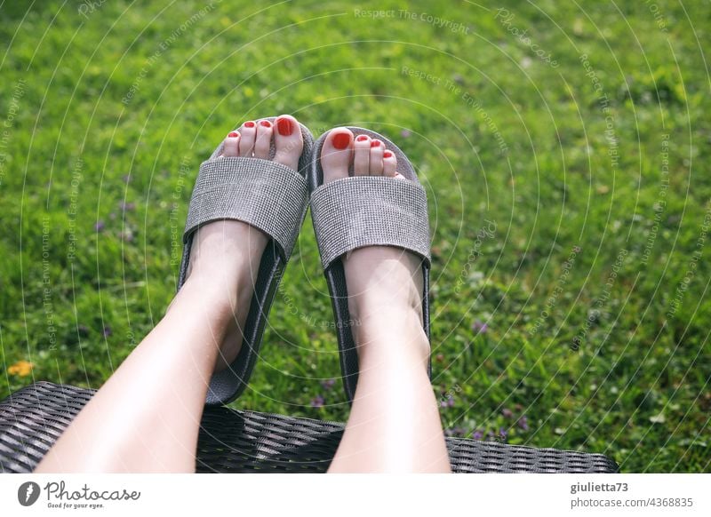 Close up of female feet in glitter bath sandals, sunbathing on lounger in garden feminine Exterior shot Summer Woman Legs Close-up High heels Garden Couch