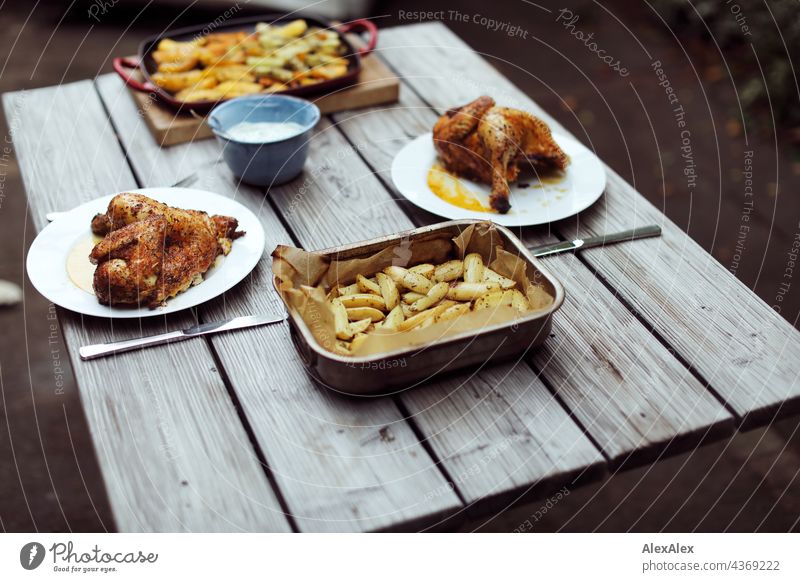 Wooden dinner table with grilled chicken, grilled potato and grilled vegetables, outside. Dinner Table Potatoes Chicken broiler Barbecue (apparatus) BBQ