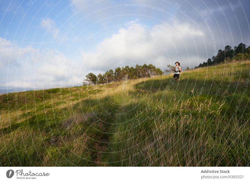 Traveling man walking in field at sunset travel backpacker summer trekking traveler evening freedom male meadow sundown nature adventure countryside vacation