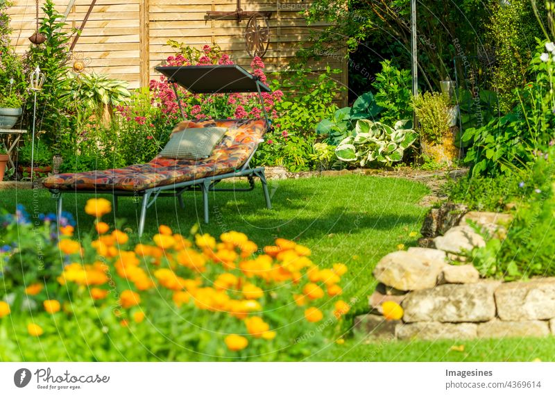 Relaxation in the landscaped garden. Garden furniture. Lounger on green grass in garden. Comfortable chair sun lounger for outdoor sunbathing. background