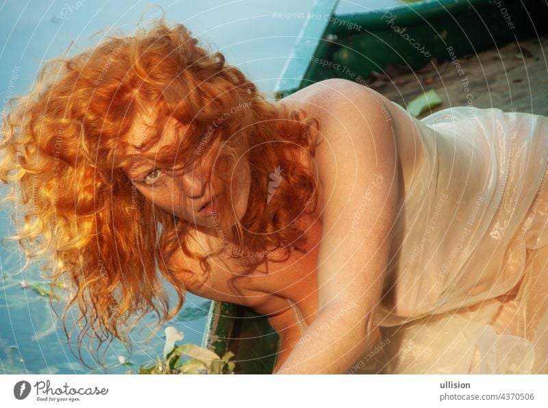 portrait of beautiful seductive sexy woman with red hair in her face, in the golden evening sunshine in a boat romantic gorgeous style vogue curly bright