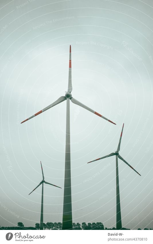 three wind turbines / wind power plants on the land Wind energy plant windmills Pinwheel Energy Energy generation stream Large