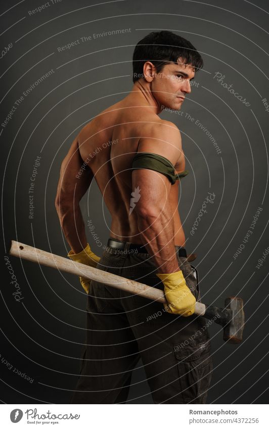 The sexy construction man holds a sledgehammer handsome sexy guy adult brave muscle muscular strong fit ample body healthy workout Musculature hair male