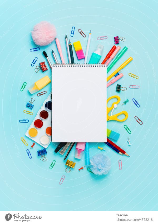 School supplies and empty notebook on blue bckg back to school school supplies stuff copy space shool blue background desk stationary white sheet notepad