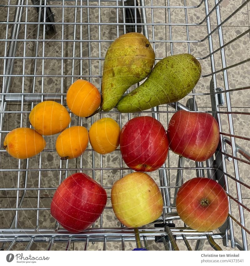 Unpacked fruit is in the shopping trolley, waste avoidance, bird's eye view Shopping Trolley unpacked unwrapped fruit unpackaged food purchasing apples pears
